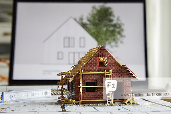 Architektur  Modell des Wohneigentums auf dem Bauplan  Laptop im Hintergrund