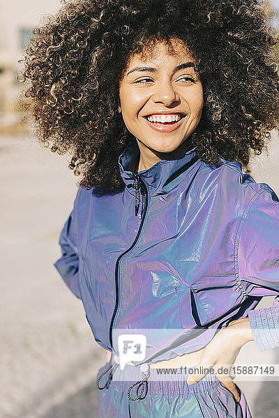 Porträt einer glücklichen  stilvollen jungen Frau im Trainingsanzug im Freien