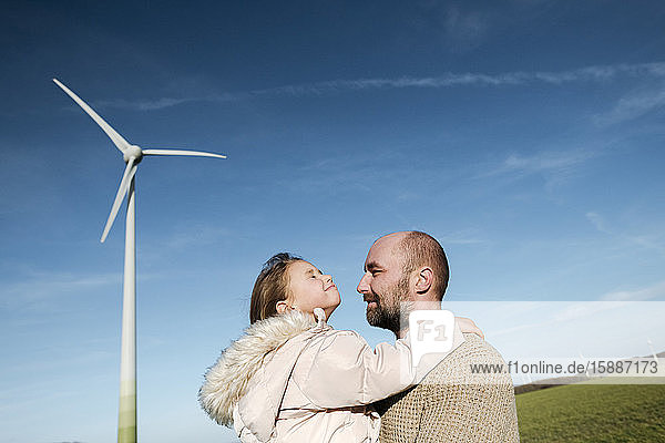 Happy father with his little daughter on a field