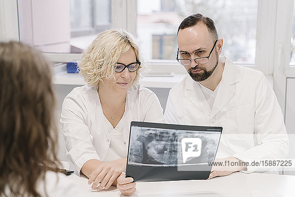 Dentists talking about x-ray results to the patient