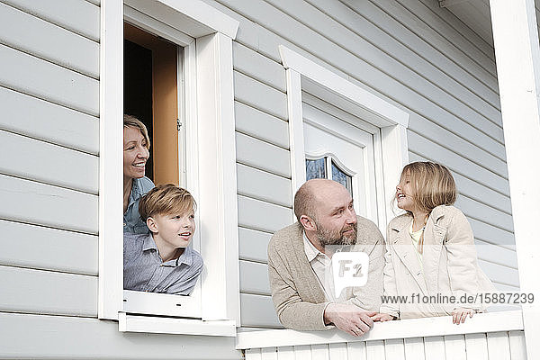 Glückliche Familie auf der Veranda ihres Hauses