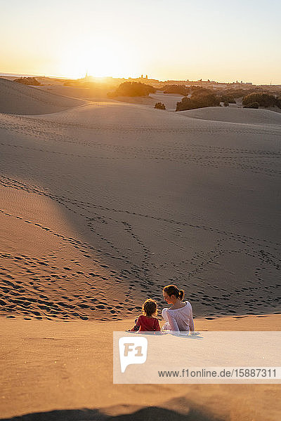 Mutter und Tochter entspannen sich bei Sonnenuntergang in Sanddünen  Gran Canaria  Spanien