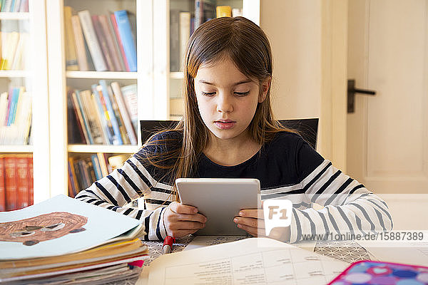 Mädchen macht Hausaufgaben mit digitalem Tablett