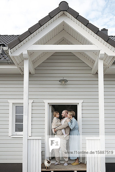 Family with cat on porch of their house