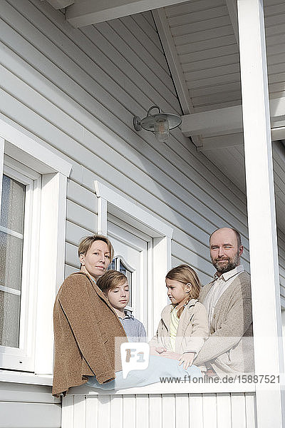 Porträt einer Familie auf der Veranda ihres Hauses