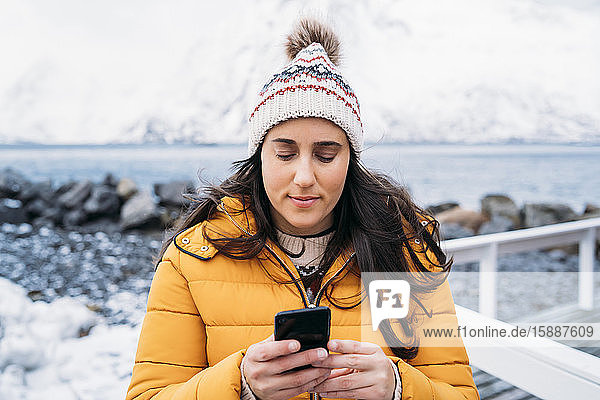 Tourist mit Handy an der Küste  Lofoten  Norwegen