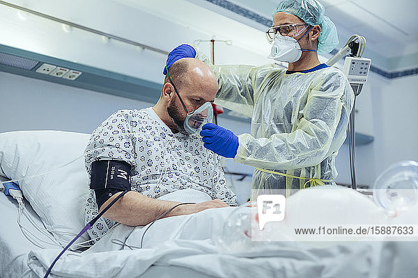 Doctor giving artificial respiration to patient in emergency care unit of a hospital