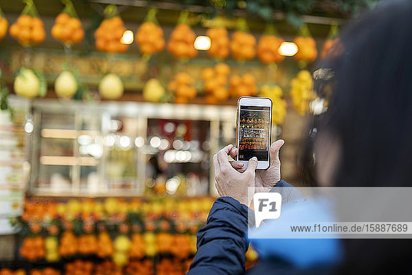 Touristin fotografiert mit ihrem Smartphone einen Imbissstand in Neapel  Italien