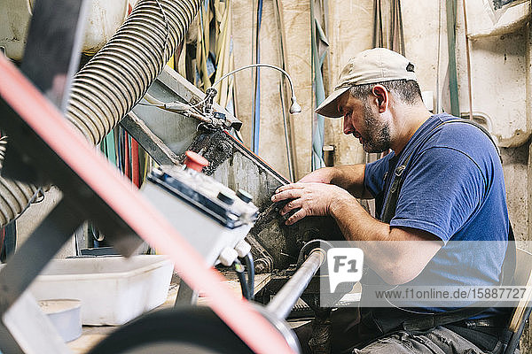 Craftsman making knives in his workshop