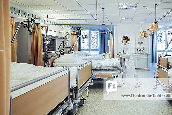 Arzt im Krankenhauszimmer schiebt Betten