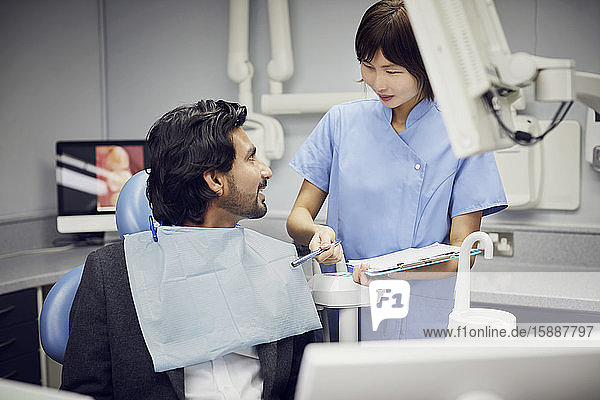 Medizinischer Sekretär bereitet Zahnbehandlung für Patient vor