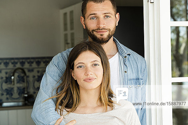 Porträt eines attraktiven jungen Paares in der Wohnungstür