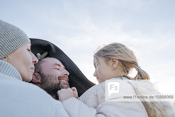 Happy parents with little daughter in winter
