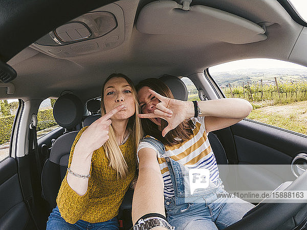 Portrait of two playful young women on a road trip