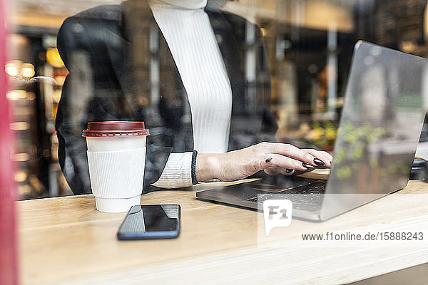 Nahaufnahme einer Geschäftsfrau mit Laptop in einem Café in der Stadt