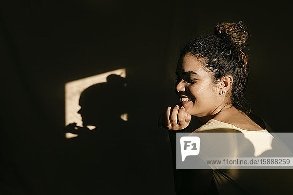 Porträt einer lächelnden attraktiven jungen Frau im Sonnenlicht