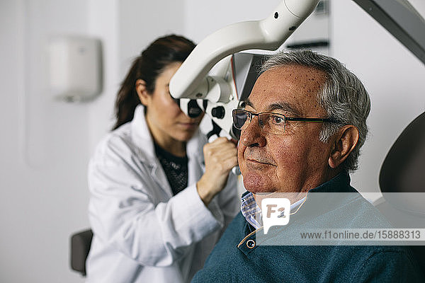 HNO-Arzt untersucht das Ohr eines älteren Mannes