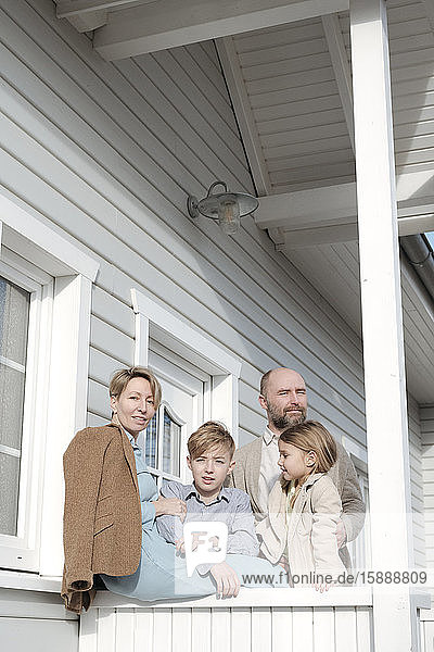 Porträt einer Familie auf der Veranda ihres Hauses