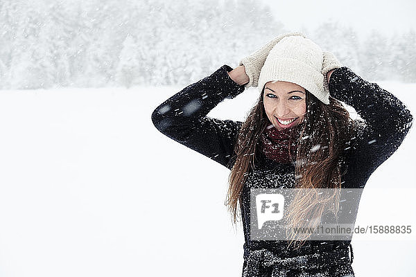 Porträt einer glücklichen jungen Frau in Winterlandschaft