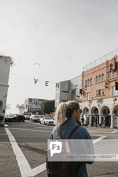 Rückenansicht einer Frau mit Rucksack auf der Straße  Venice Beach  Los Angeles  USA