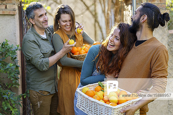 Glückliche Freunde halten einen Korb mit Zitronen und Orangen