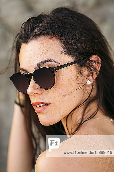 Junge Frau mit Sonnenbrille am Strand