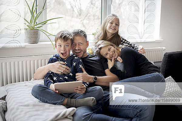 Porträt einer verspielten Familie auf der Couch zu Hause