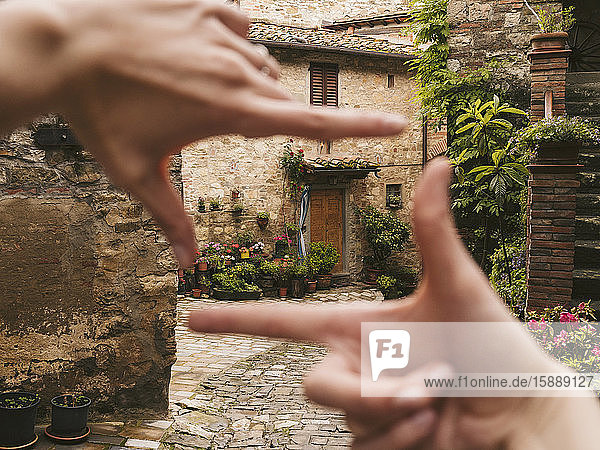 Frau rahmt mit dem Finger ein Haus in der malerischen Altstadt ein  Greve in Chianti  Toskana  Italien