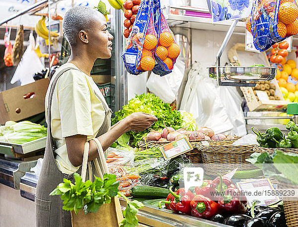 Frau kauft Lebensmittel in einer Markthalle