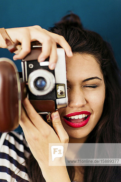Porträt einer jungen Frau mit roten Lippen  die den Betrachter mit der Kamera fotografiert
