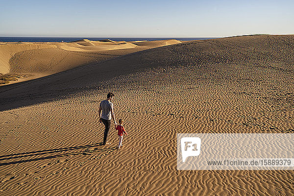 Vater und Tochter gehen Hand in Hand in den Sanddünen  Gran Canaria  Spanien