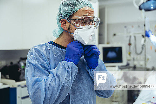 Arzt  der in der Notaufnahme eines Krankenhauses eine ffp2-Maske aufsetzt