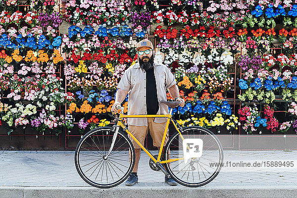 Porträt eines bärtigen Mannes mit Fixie-Bike und verspiegelter Sonnenbrille