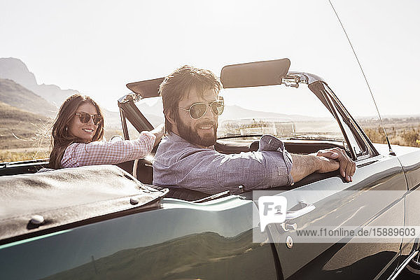 Paar in einem Cabriolet auf einer Autoreise