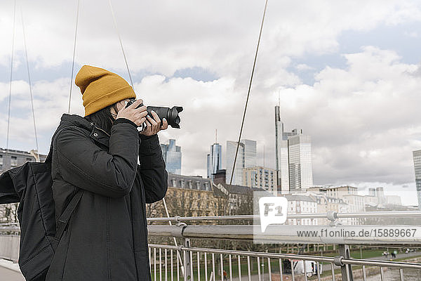 Tourist taking picture with a camera on a bridge  Frankfurt  Germany