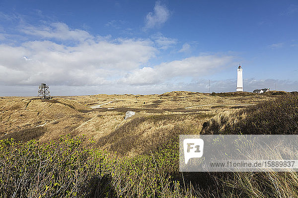 Dänemark  Romo  Blavand  Wolken über grasbewachsener Küstenlandschaft mit Leuchtturm im Hintergrund