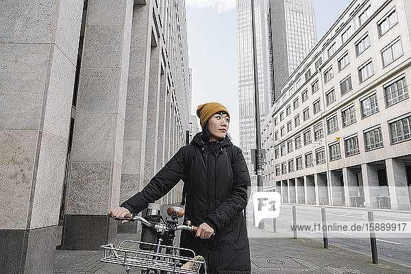 Frau mit Fahrrad in der Stadt  Frankfurt  Deutschland