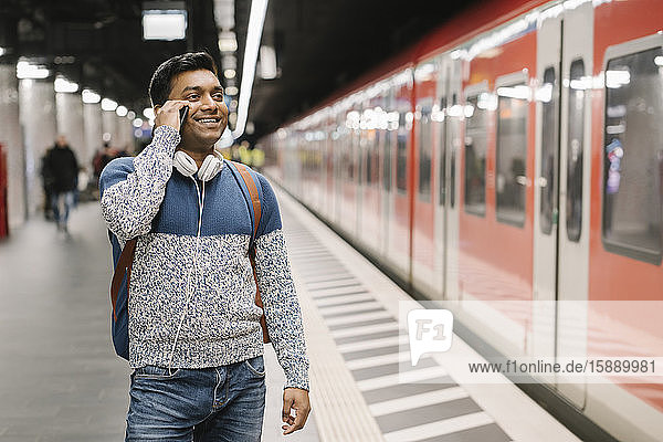Smiling man on the phone in subway station