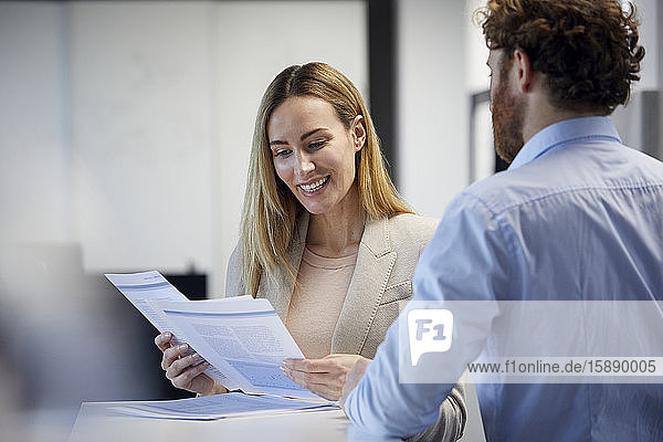 Businessman and businesswoman working together on papers in office