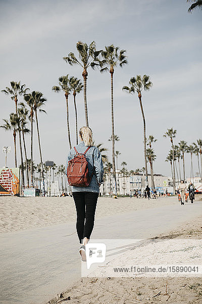 Rückenansicht einer gehenden Frau mit Rucksack  Venice Beach  Los Angeles  USA