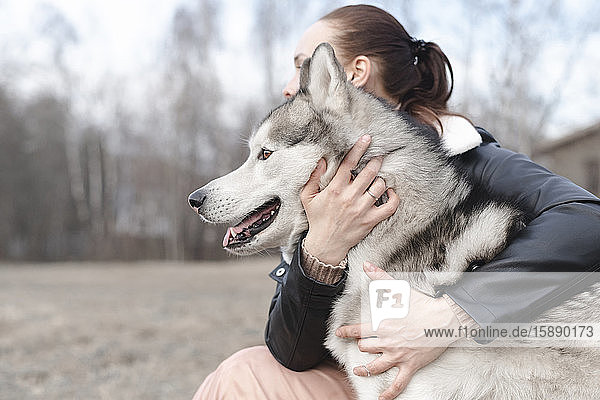 Frau umarmt ihren Hund