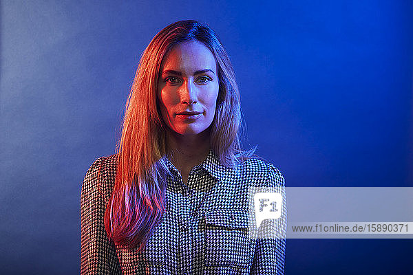 Portrait of woman in front of a blue wall