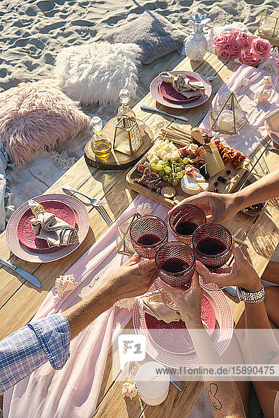 Hochwinkelansicht von Freunden beim Anstossen mit Weingläsern während eines Picknicks am Strand an einem sonnigen Tag  Riviera Nayarit  Mexiko