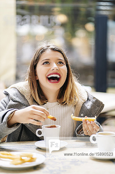 Porträt einer lachenden jungen Frau in einem Straßencafé