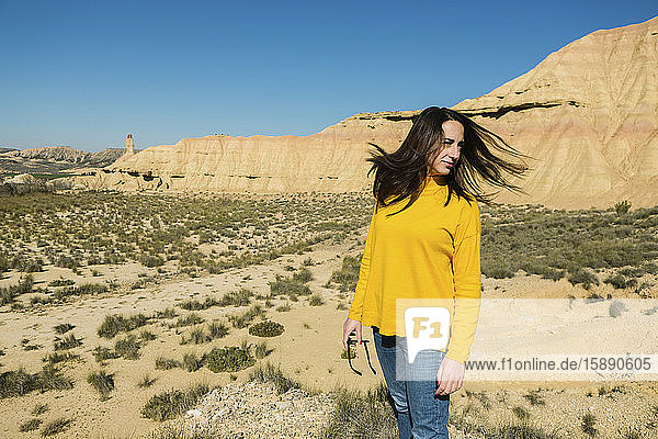 Frau schüttelt ihr Haar in der wüstenhaften Landschaft von Bardenas Reales  Arguedas  Navarra  Spanien