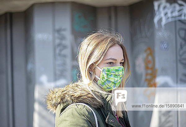 Porträt einer jungen Frau mit Maske in der Stadt