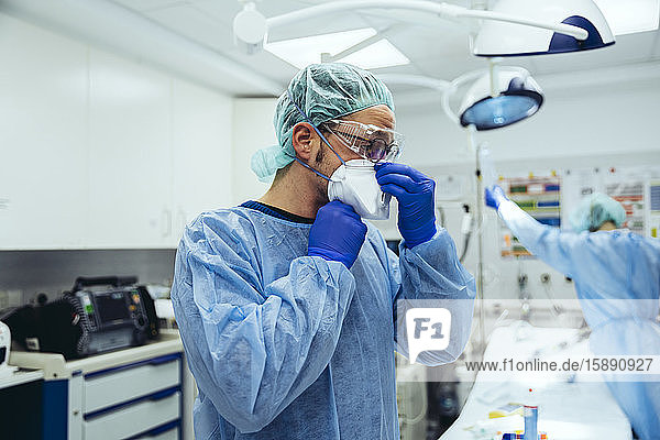 Arzt  der in der Notaufnahme eines Krankenhauses eine ffp2-Maske aufsetzt
