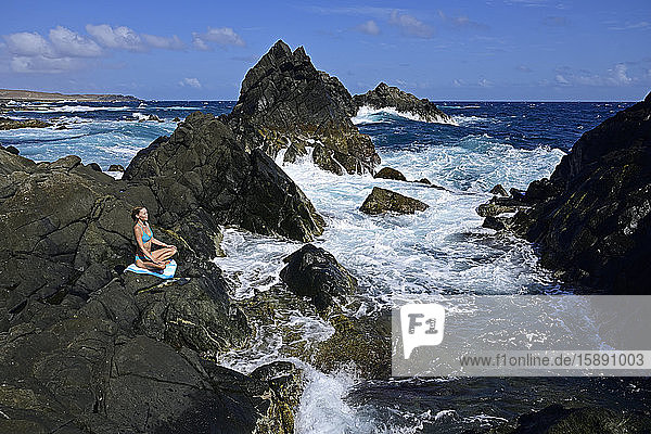Frau meditiert am Naturschwimmbecken  Arikok-Nationalpark  Aruba  Antillen