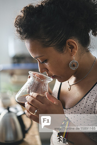 Woman working in a coffee roastery smelling at coffee