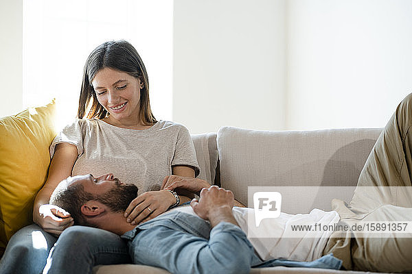 Affectionate young couple in love relaxing on couch at home